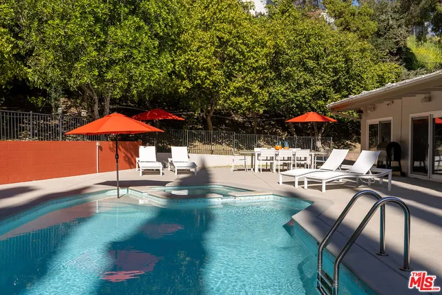 a patio with a table and chairs under an umbrella