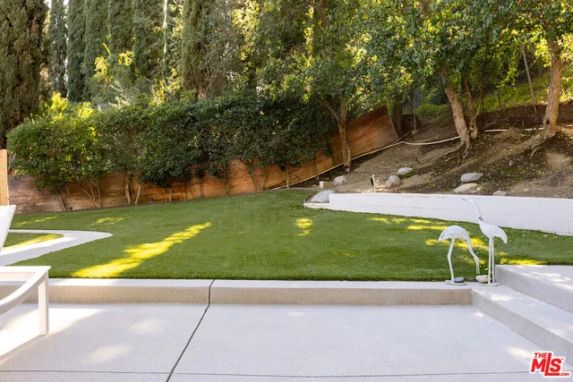 a view of yard with swimming pool and green space