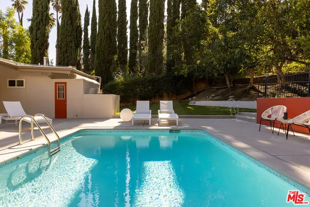 a view of a house with backyard and sitting area