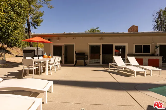 a view of a patio with table and chairs with wooden floor and fence