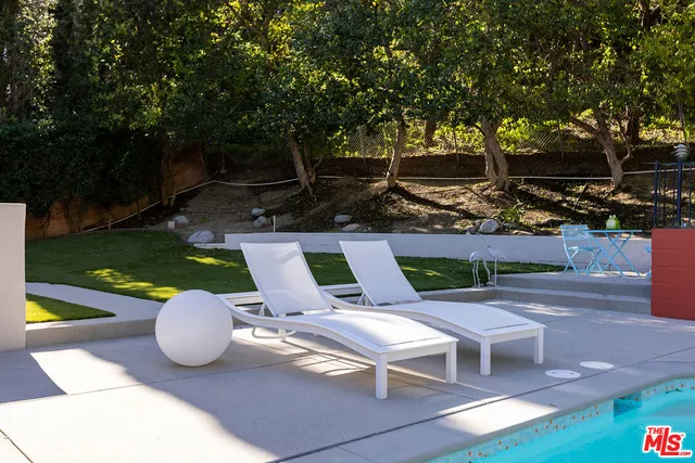 a view of a chairs and table in backyard