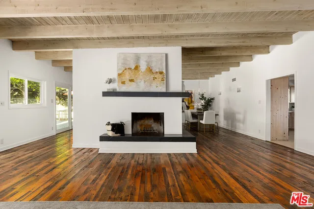 a view of a livingroom with wooden floor and a fireplace