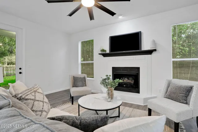 a living room with furniture a flat screen tv and a fireplace