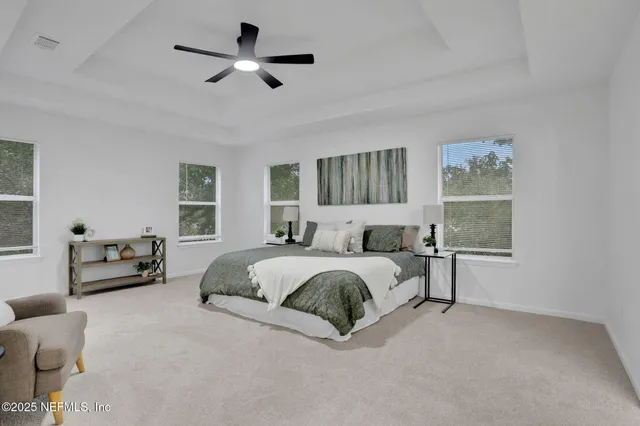 a spacious bedroom with a bed couch and window