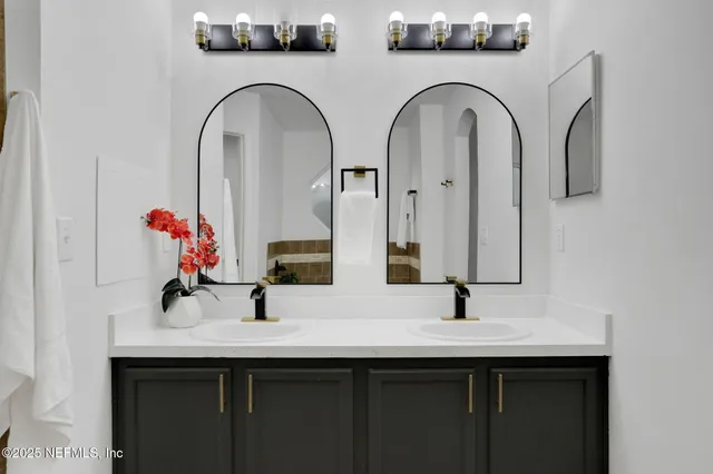 a bathroom with double vanity sinks and a mirror