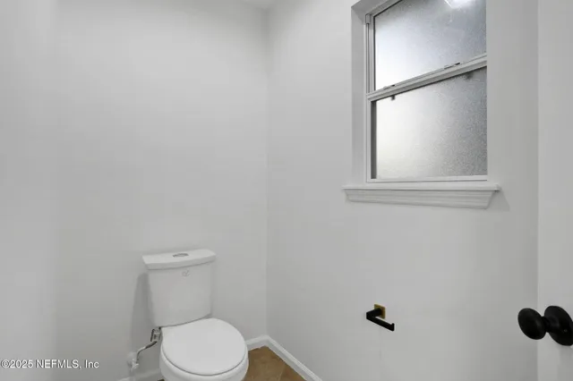 a white toilet sitting next to a window