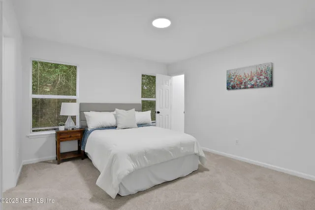 a bedroom with a bed and a large window