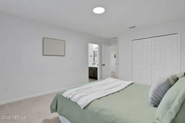 a bedroom with a bed and a painting on the wall