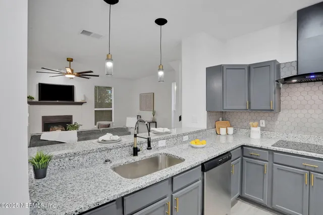 a kitchen with a sink a counter space appliances and cabinets