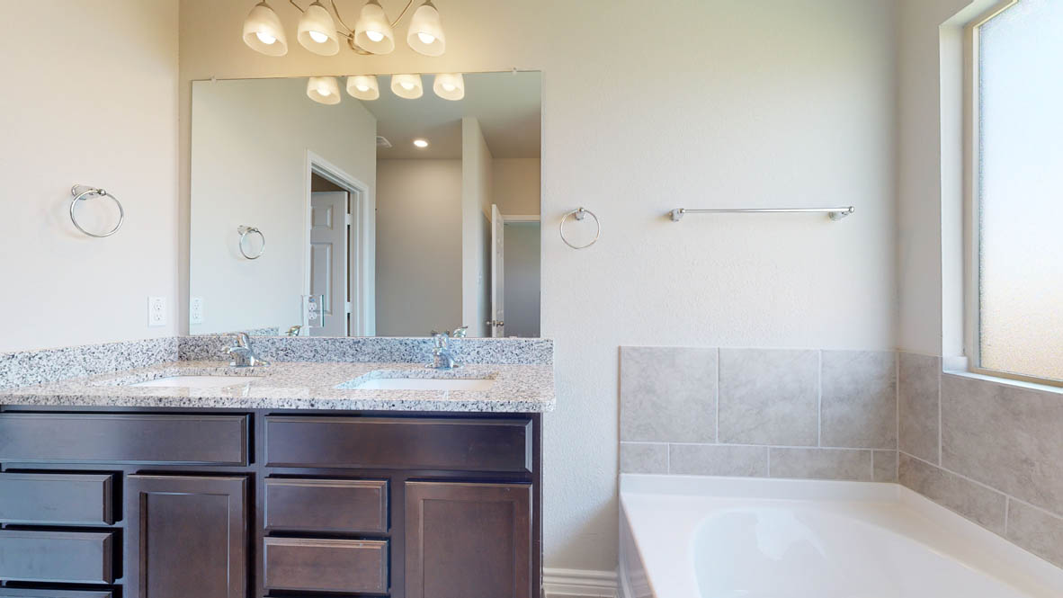 104 Kenzie Street Thorndale, TX 76577 - Photo 15 of 28 a bathroom with a granite countertop sink a large mirror and shower