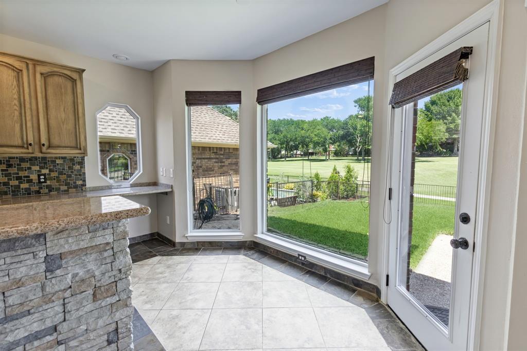 2925 Sunset Ridge McKinney, TX 75072 - Photo 11 of 33 Charming breakfast area surrounded by oversized windows, offering serene golf course views and direct access to the outdoor patio for effortless indoor-outdoor living.