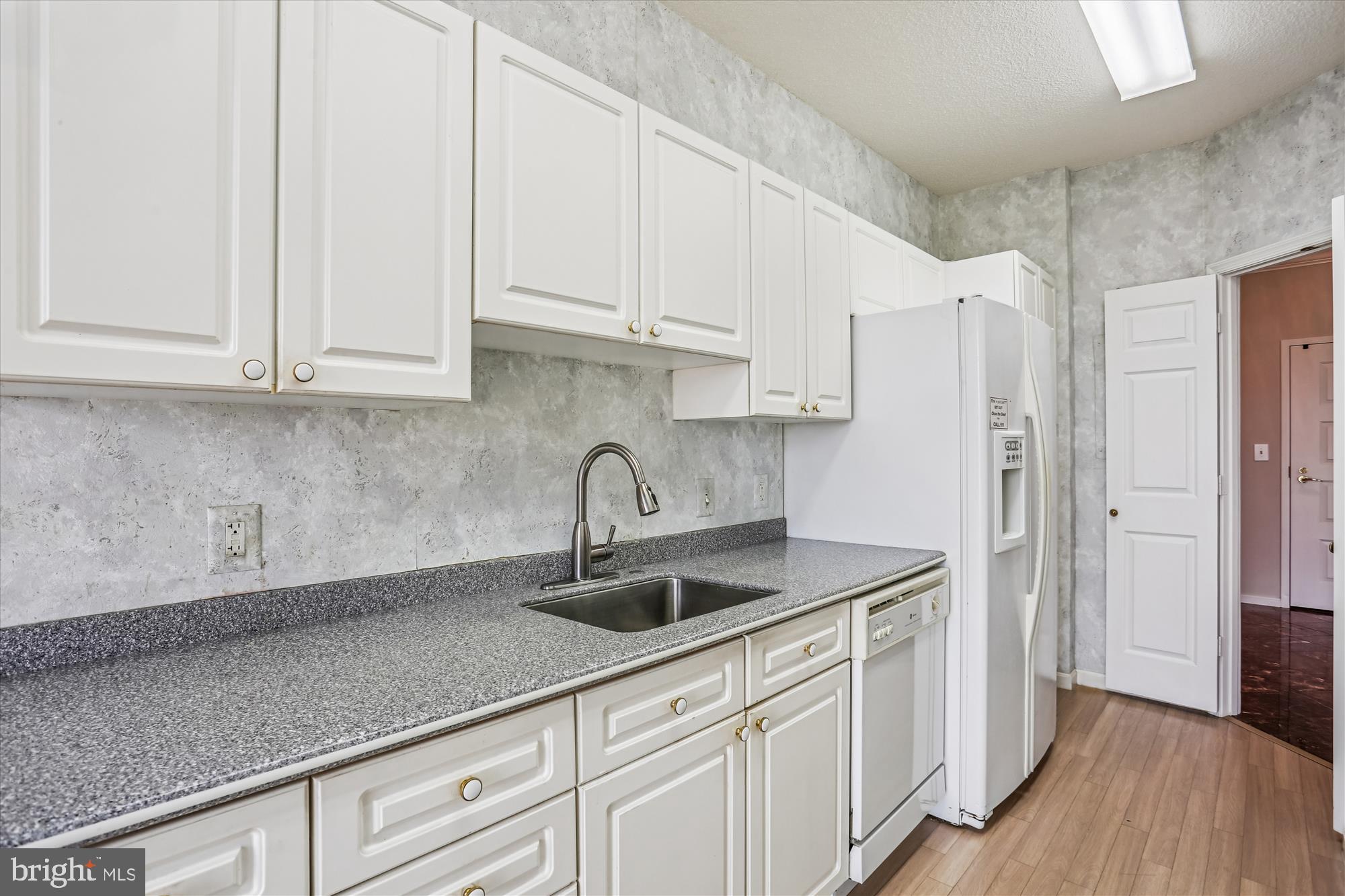 3210 North Leisure World Boulevard, Unit 610 Silver Spring, MD 20906 - Photo 10 of 97 a kitchen with stainless steel appliances granite countertop a sink a refrigerator and white cabinets