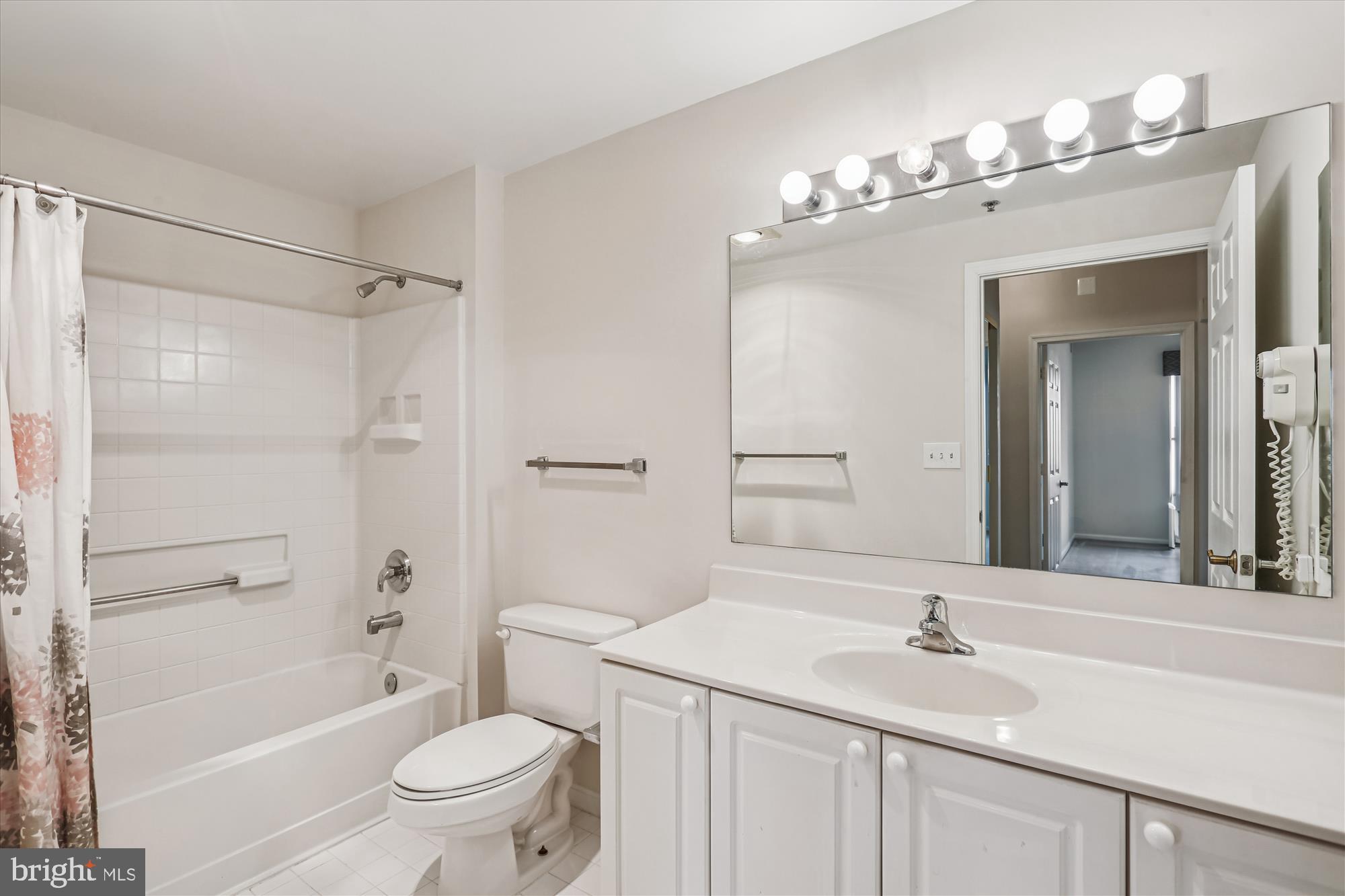 3210 North Leisure World Boulevard, Unit 610 Silver Spring, MD 20906 - Photo 42 of 97 a bathroom with a sink a toilet a mirror a vanity a bathtub and shower