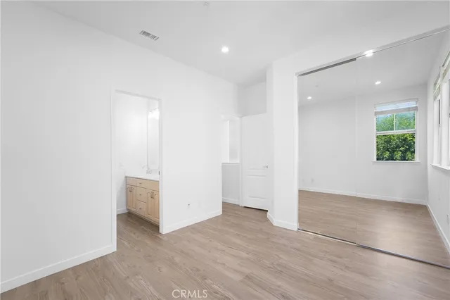 an empty room with wooden floor & windows
