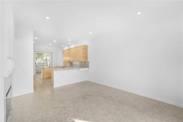 a view of an empty room and a kitchen