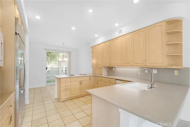 a large kitchen with granite countertop a sink and a stove top oven