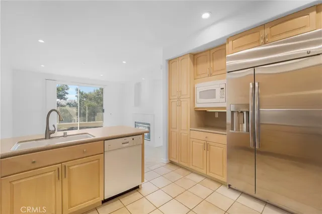 a kitchen with white cabinets and refrigerator
