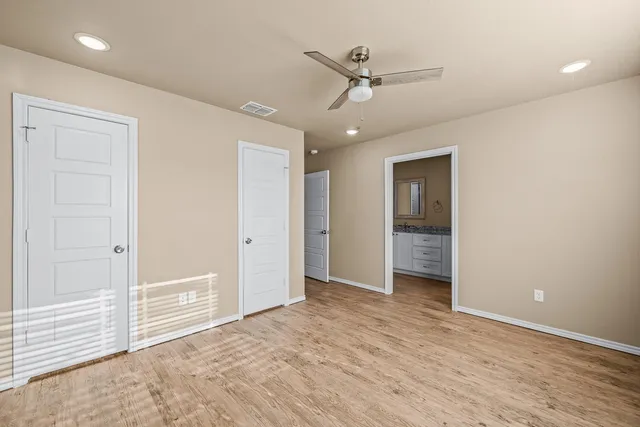 an empty room with closet and a ceiling fan
