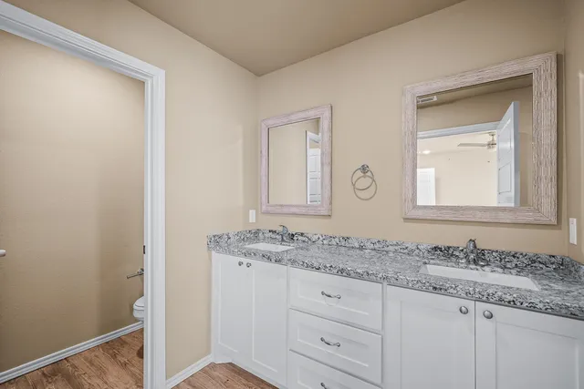 a bathroom with a granite countertop sink and mirror with window