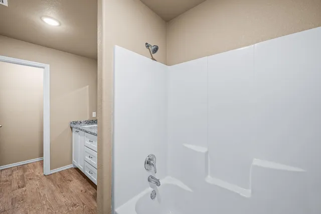 a bathroom with a granite countertop sink a mirror and a bathtub