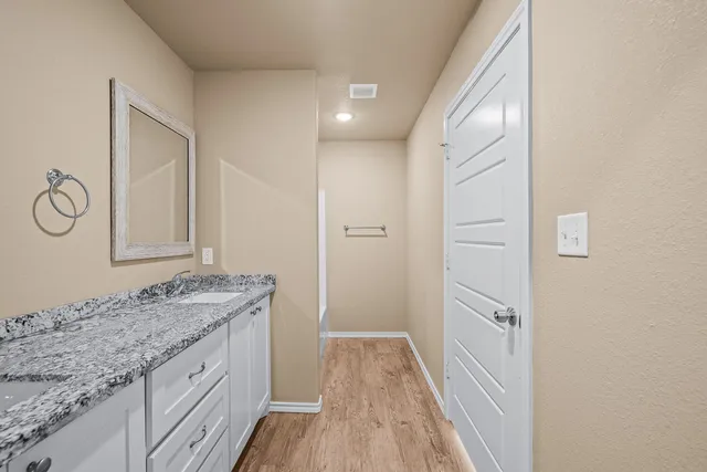 a bathroom with a granite countertop sink and a mirror