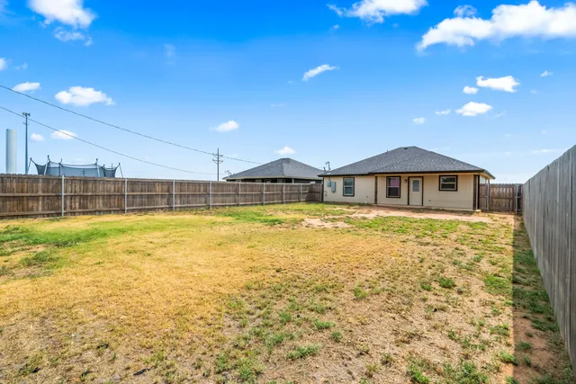a view of a swimming pool with a lawn chairs under an umbrella