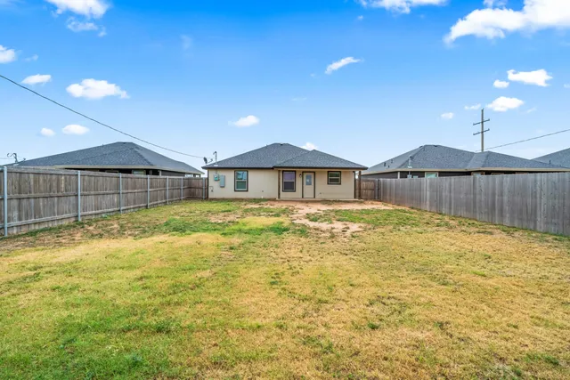 a swimming pool with yard and wooden fence