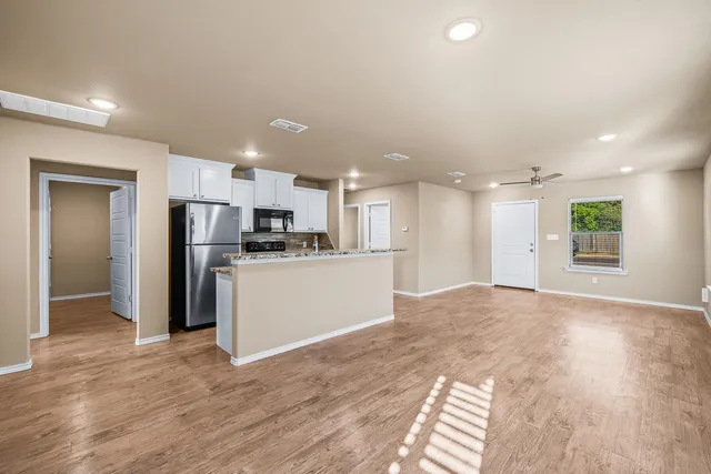 a view of kitchen with refrigerator and microwave