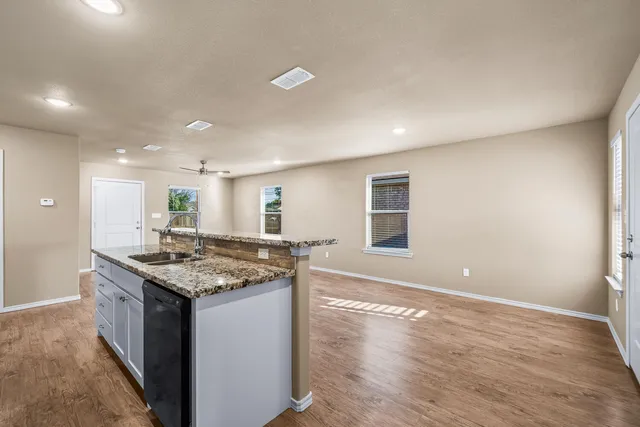a kitchen with a stove a sink a refrigerator and a counter top space
