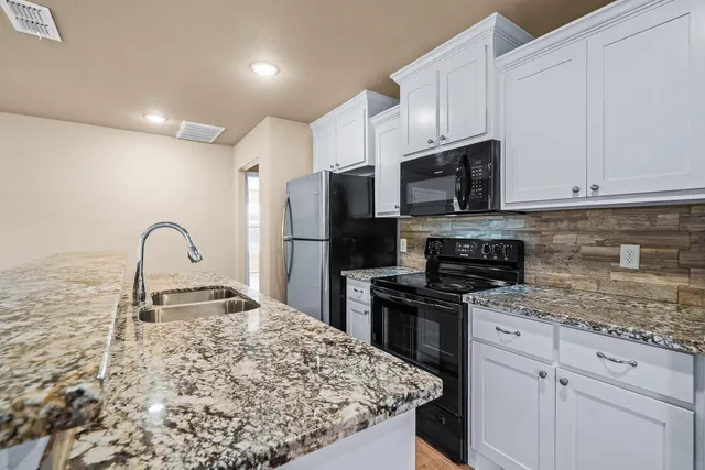 a kitchen with kitchen island a sink appliances and cabinets