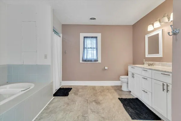 a bathroom with a granite countertop sink a toilet and a mirror