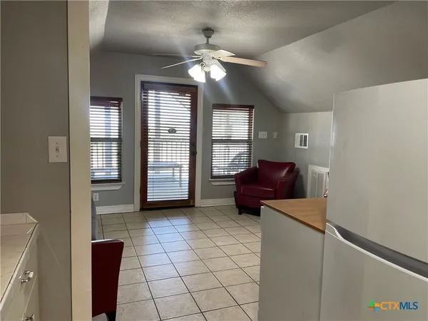 a living room with furniture and two windows