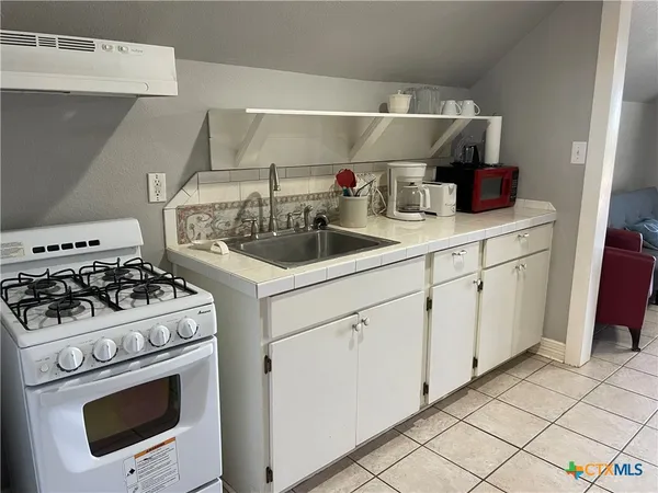 a kitchen with white cabinets and white appliances