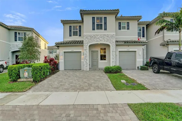 a front view of a house with a yard and garage