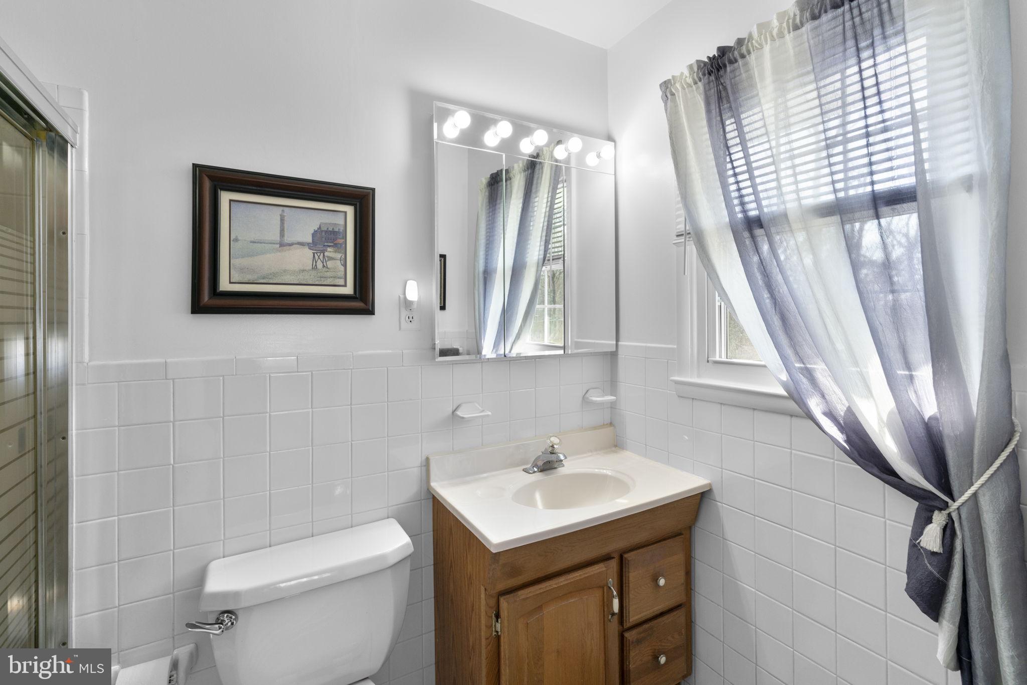 943 Homberg Avenue Baltimore, MD 21221 - Photo 14 of 34 a bathroom with a sink a toilet and a mirror