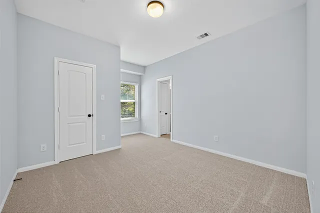 an empty room with windows and closet