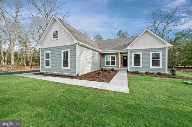 a front view of a house with a yard and trees