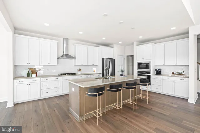 a kitchen with white cabinets stove and white stainless steel appliances