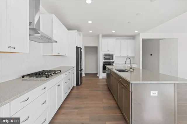 a large kitchen with stainless steel appliances granite countertop a stove a sink dishwasher and a refrigerator