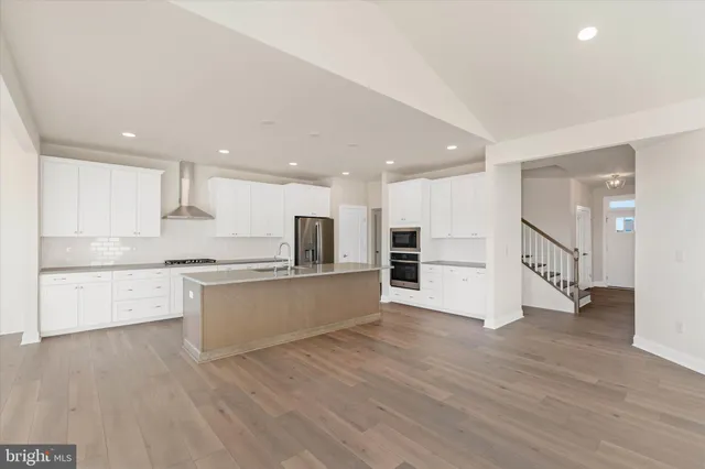 a large kitchen with stainless steel appliances refrigerator sink and cabinets