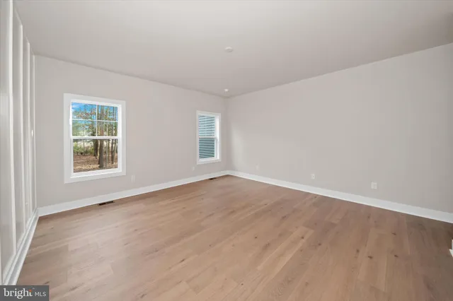 an empty room with windows and fireplace