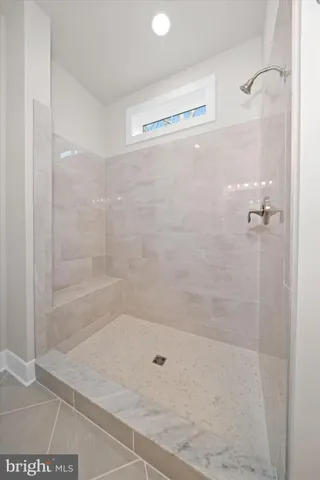 a large kitchen with white cabinets stainless steel appliances and a center island