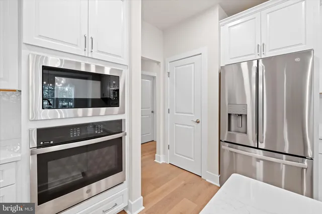 a kitchen with stainless steel appliances granite countertop a refrigerator a stove a sink dishwasher and a refrigerator with wooden floor