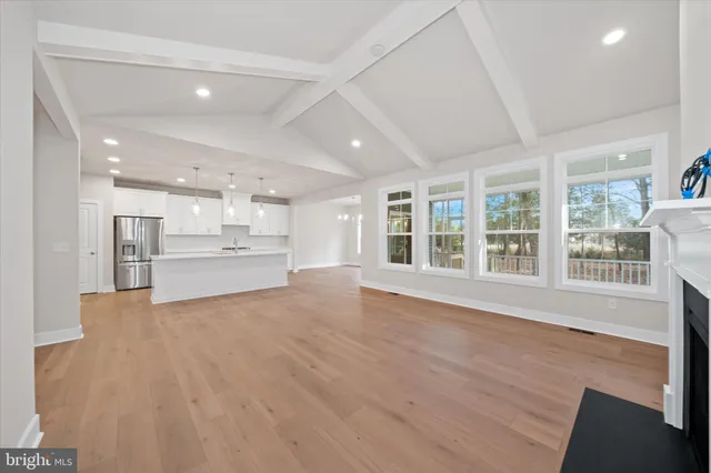 a kitchen with granite countertop a stove a sink dishwasher and white cabinets with wooden floor