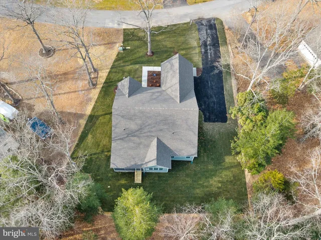a aerial view of a house with a yard and large trees
