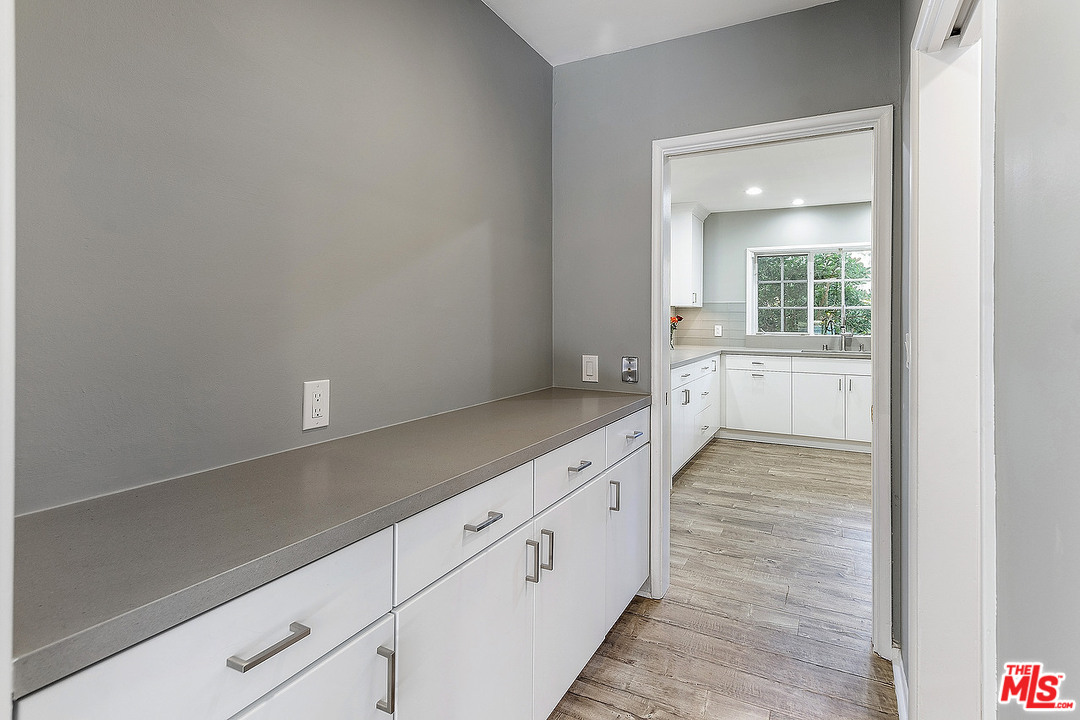 711 Sierra Drive Beverly Hills, CA 90210 - Photo 14 of 40 a hallway with white cabinets and wooden floor