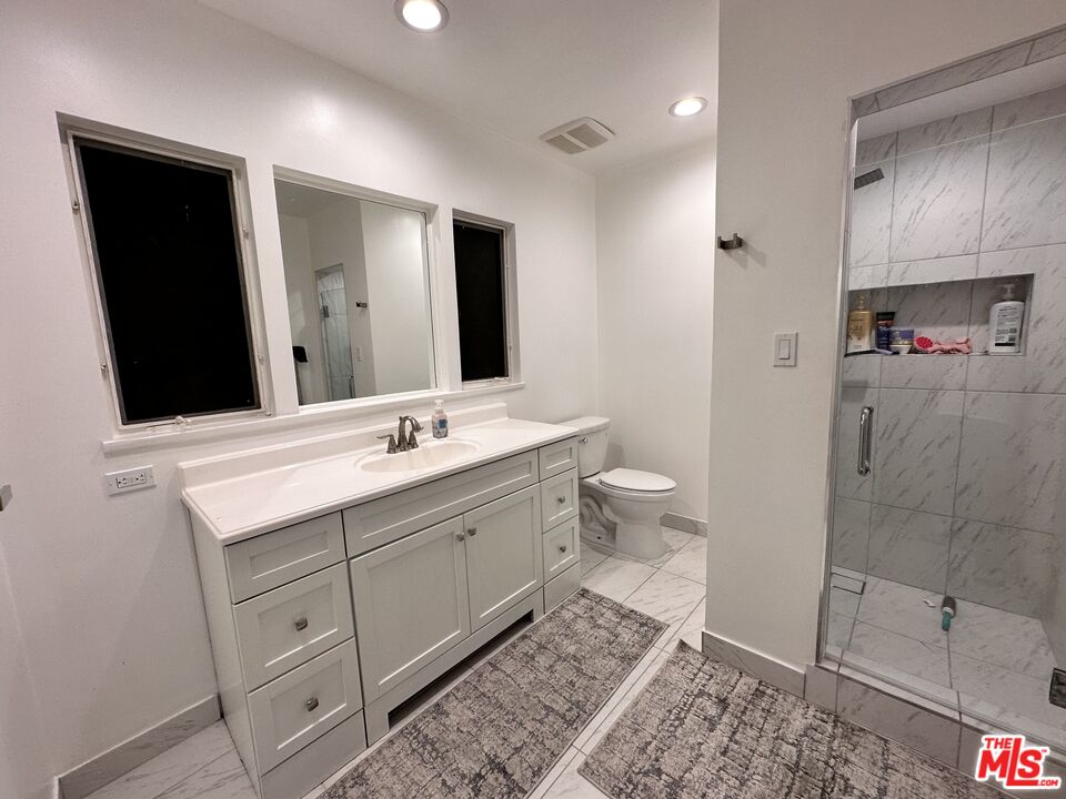711 Sierra Drive Beverly Hills, CA 90210 - Photo 28 of 40 a bathroom with a double vanity sink toilet and shower