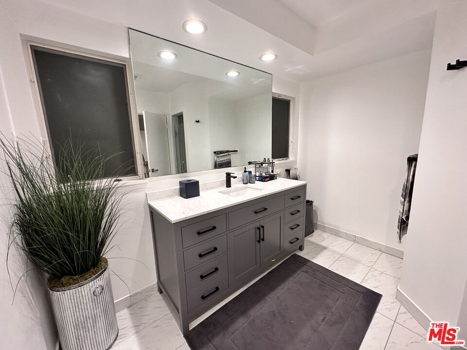 711 Sierra Drive Beverly Hills, CA 90210 - Photo 33 of 40 a bathroom with a double vanity sink a and mirror