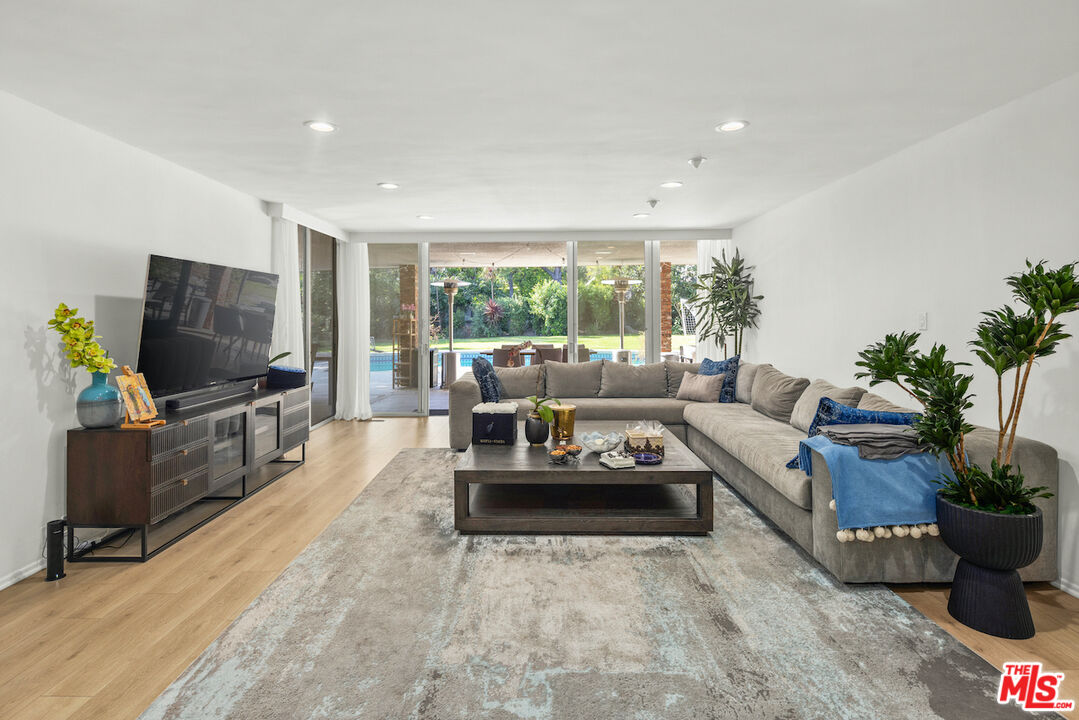 711 Sierra Drive Beverly Hills, CA 90210 - Photo 5 of 40 a living room with furniture and a flat screen tv
