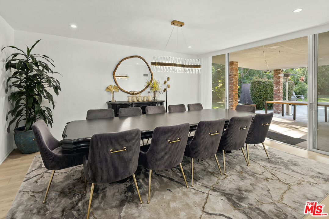 711 Sierra Drive Beverly Hills, CA 90210 - Photo 8 of 40 a dining room with furniture a chandelier and wooden floor